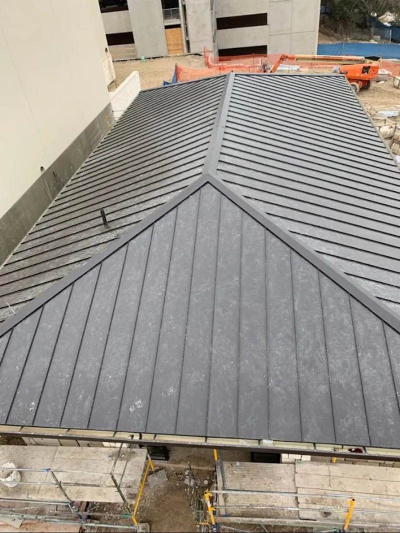 Commercial metal roof construction with crane equipment in San Martin